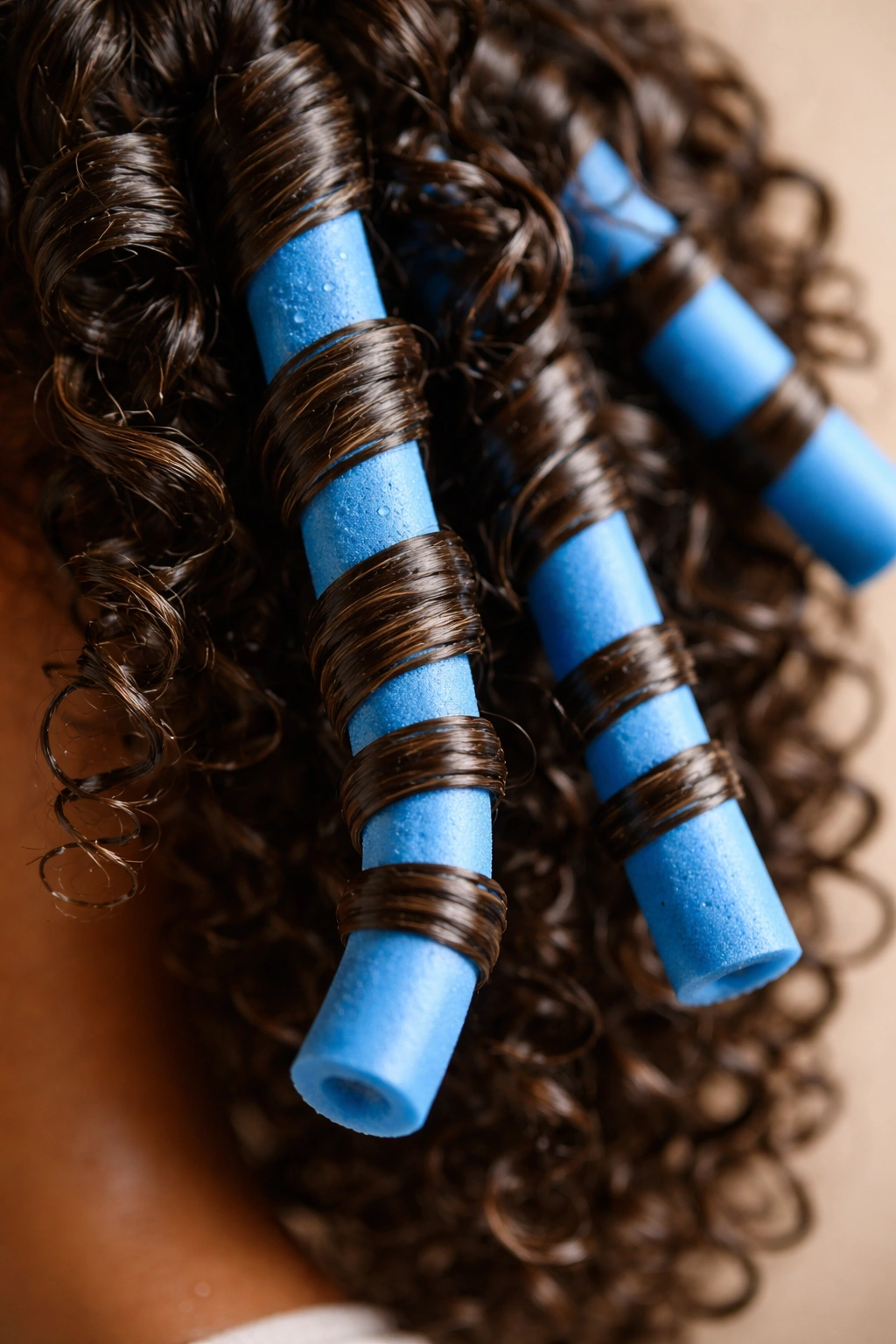 Damp curls wrapped around a blue flexi-rod for a curl refresh