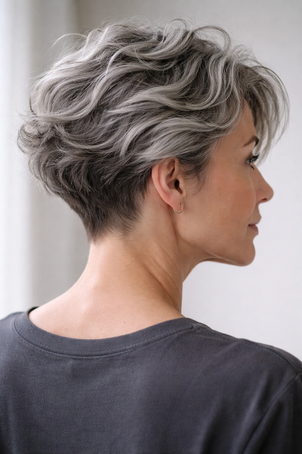 Gray hair showing textured waves and a subtle undercut detail