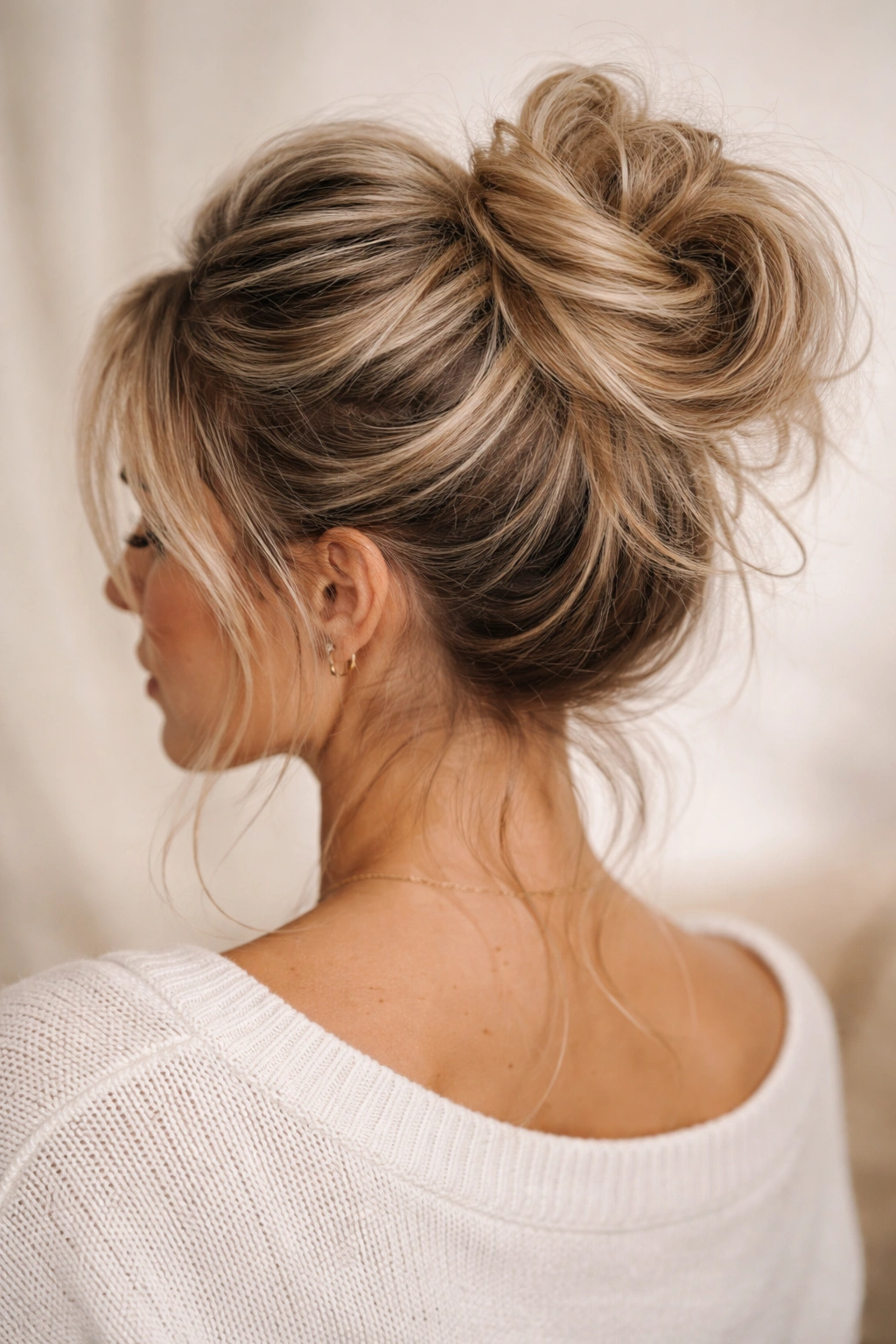 Teased high ponytail wrapped into a textured messy bun