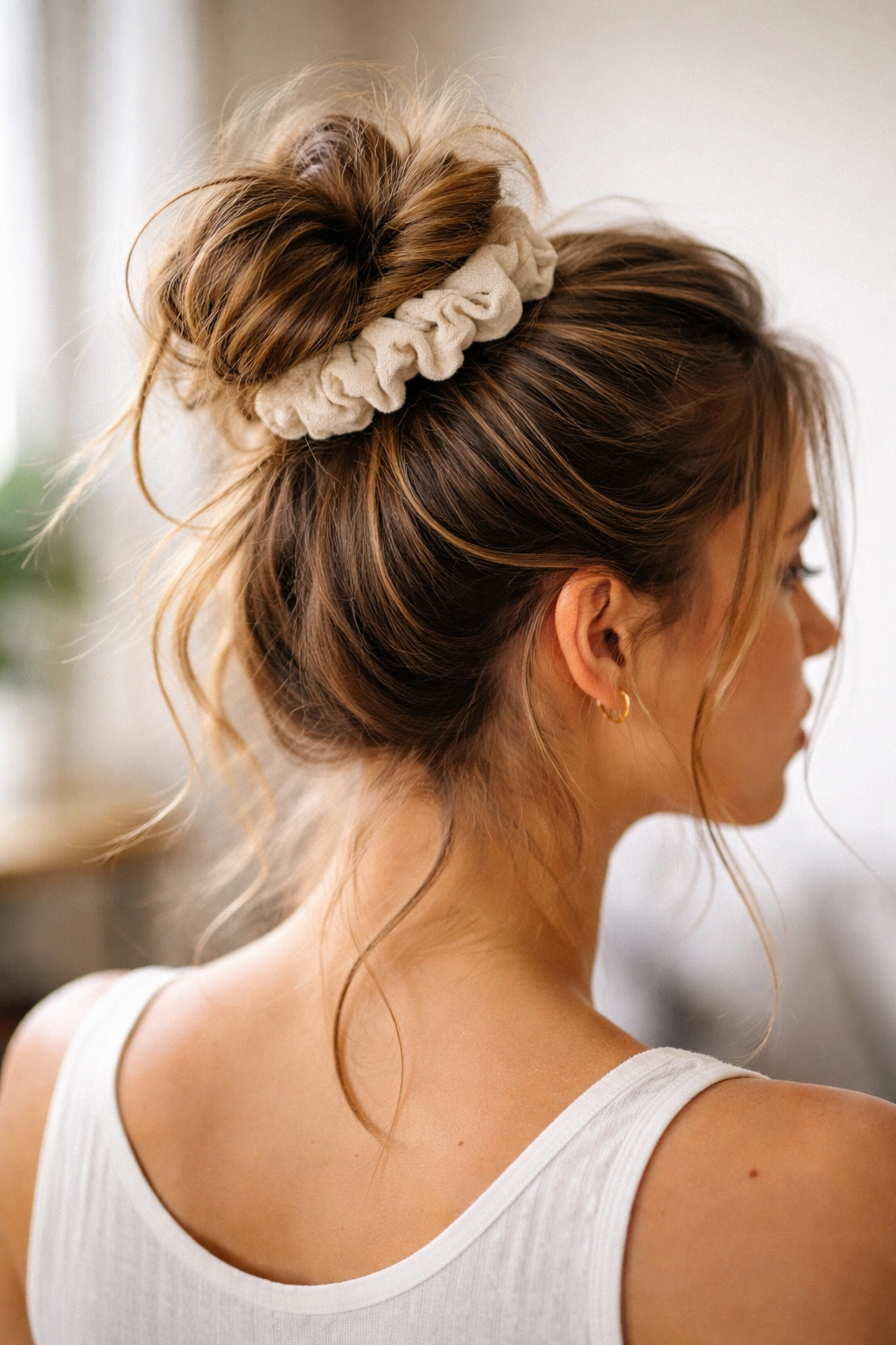Casual undone top knot with scrunchie and loose ends cascade.