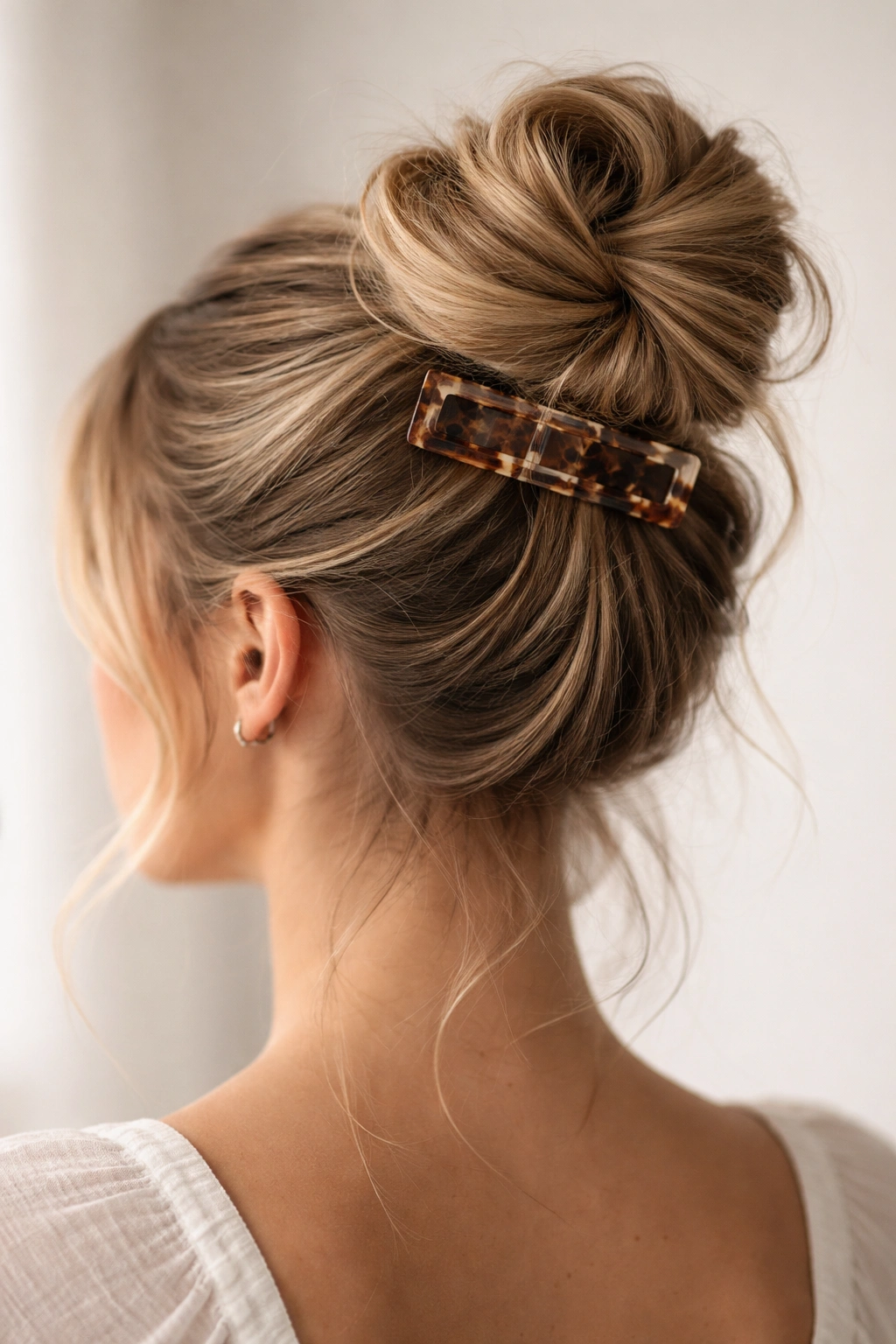 High twisted bun secured with a claw clip at the crown
