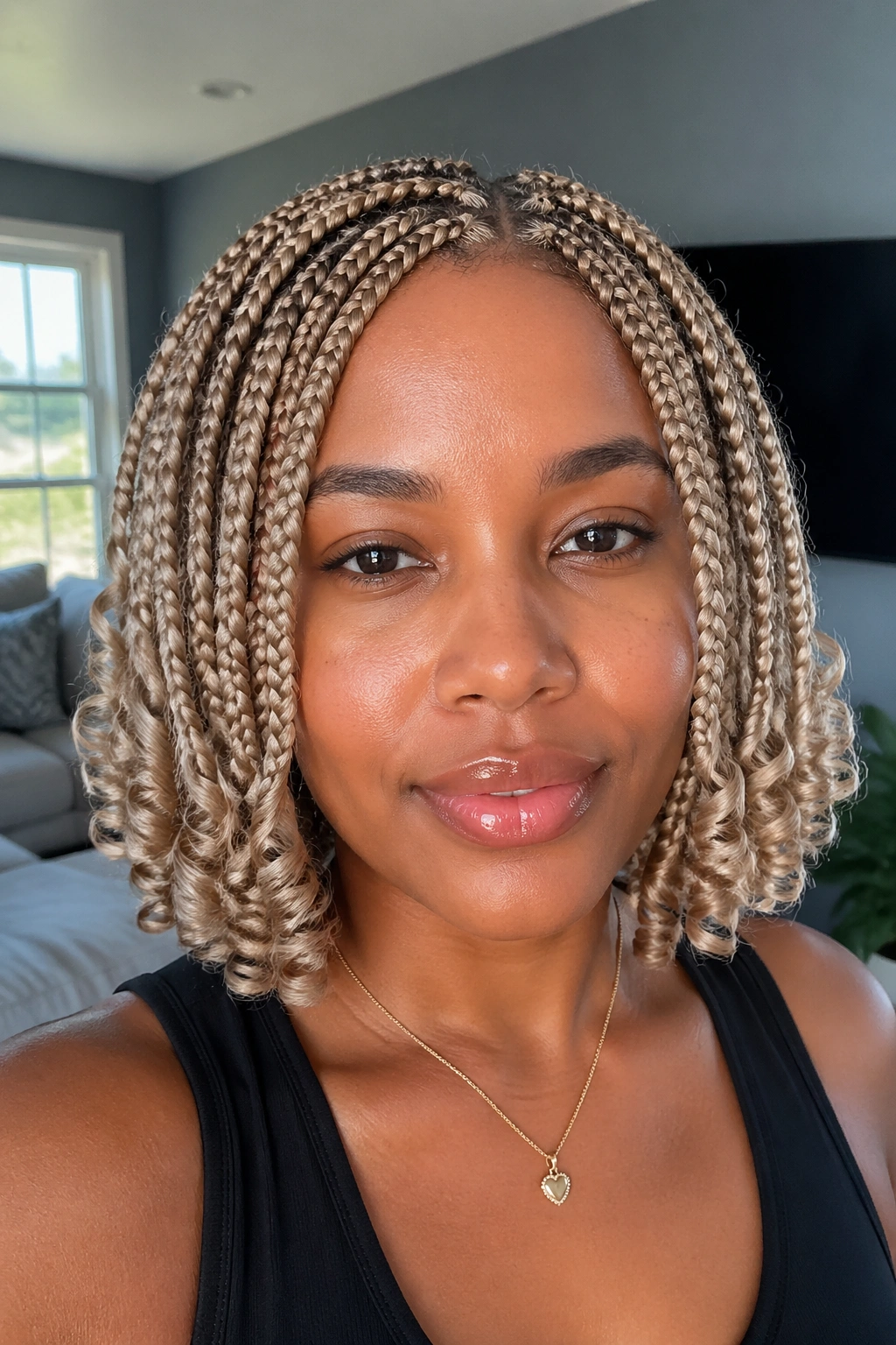 Close-up of a real woman with ash blonde short box braids and corkscrew ends.