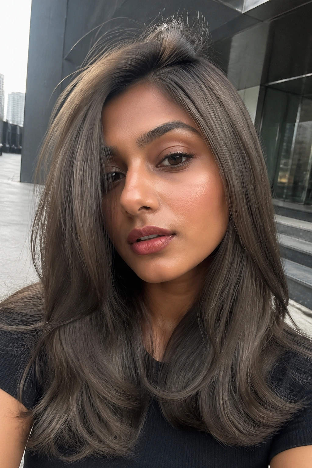 Close-up portrait of ash brown hair against an urban backdrop