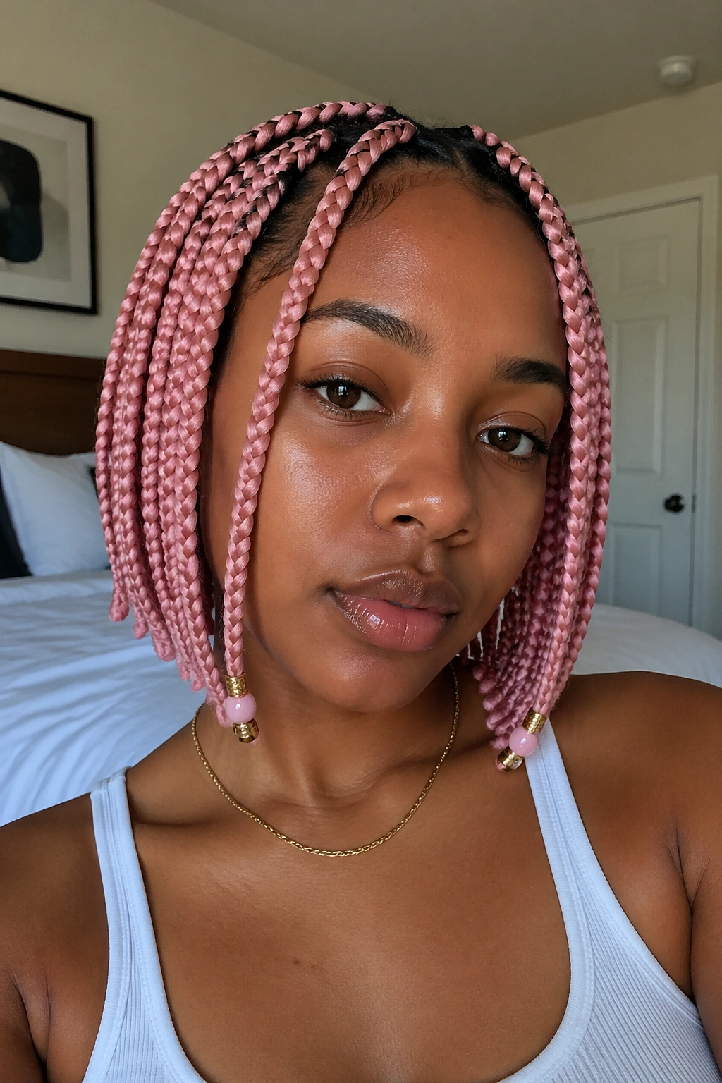 Close-up portrait of a real woman with beaded pink box braids around her face with 2-3 accent beads.