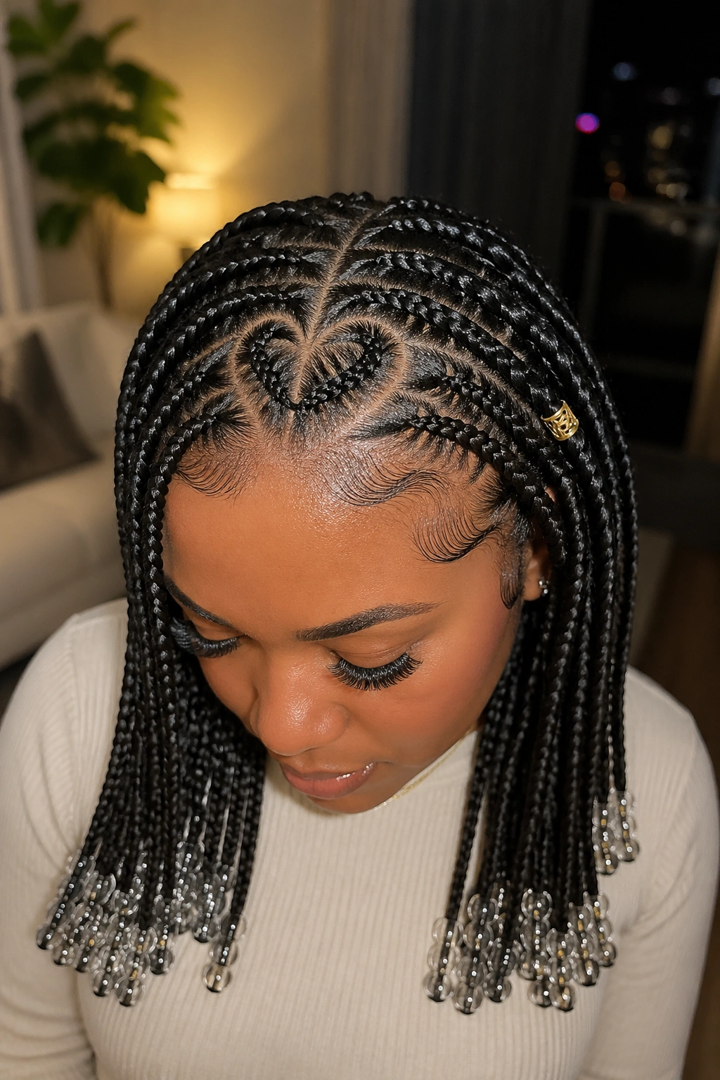Beads and a heart detail in knotless braids on a real person