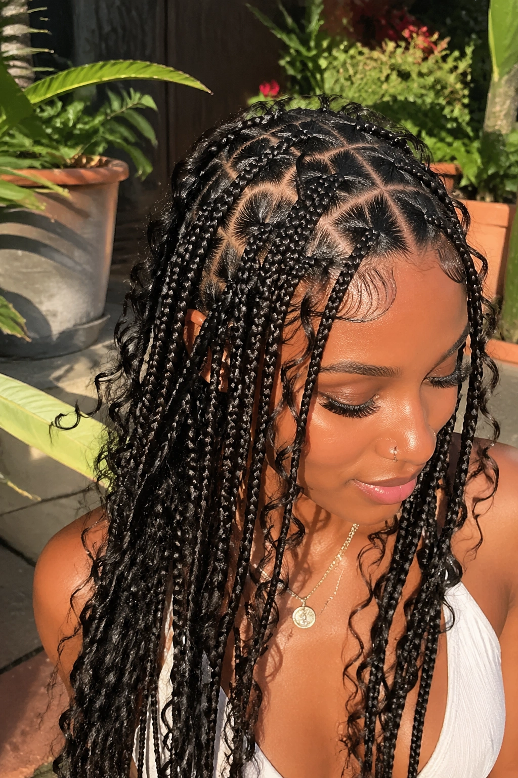 Close-up of boho knotless braids with soft heart parts and loose curls on a real person