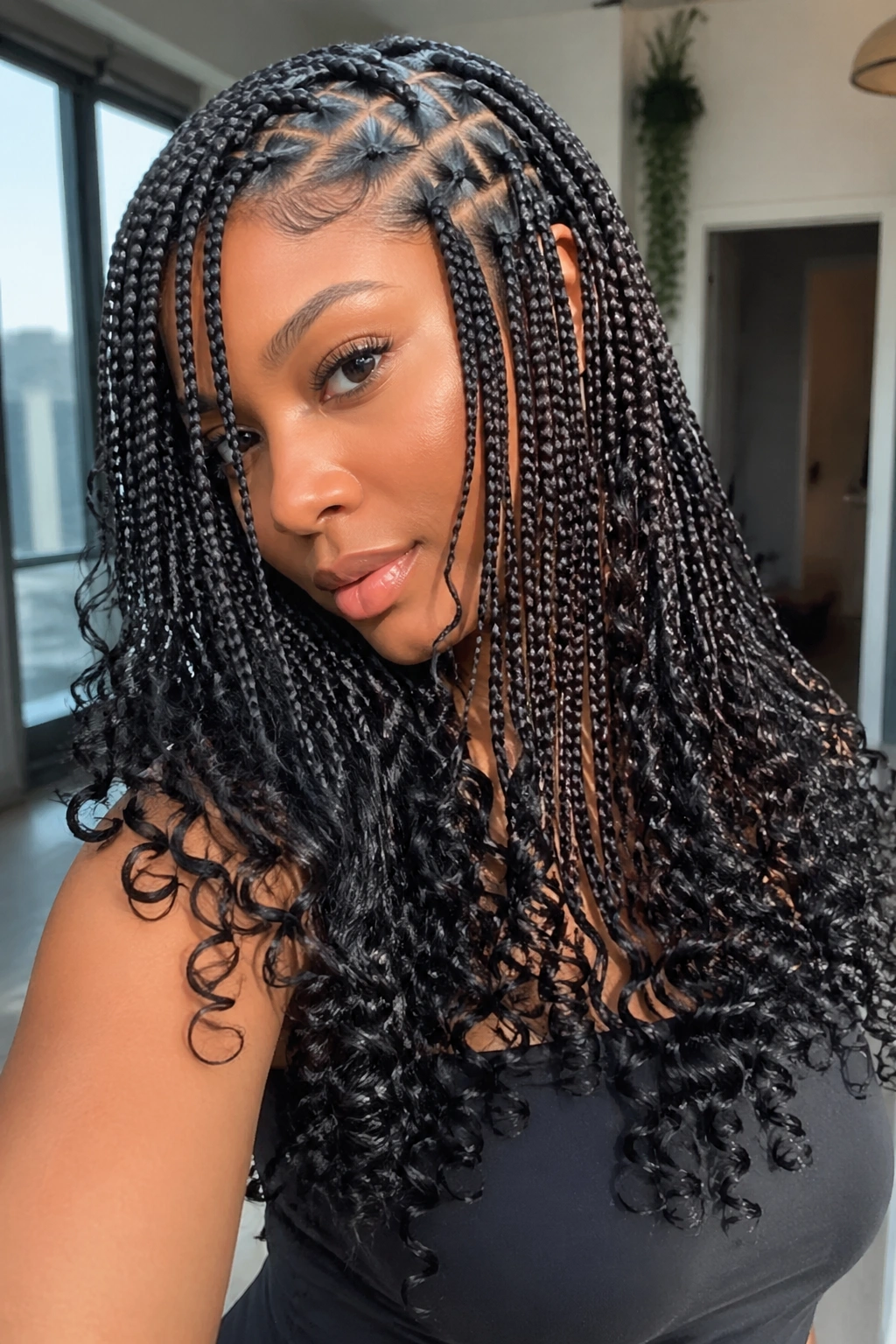 Close-up of a real person with a deep side part and curl flip on triangle-part braids in daylight