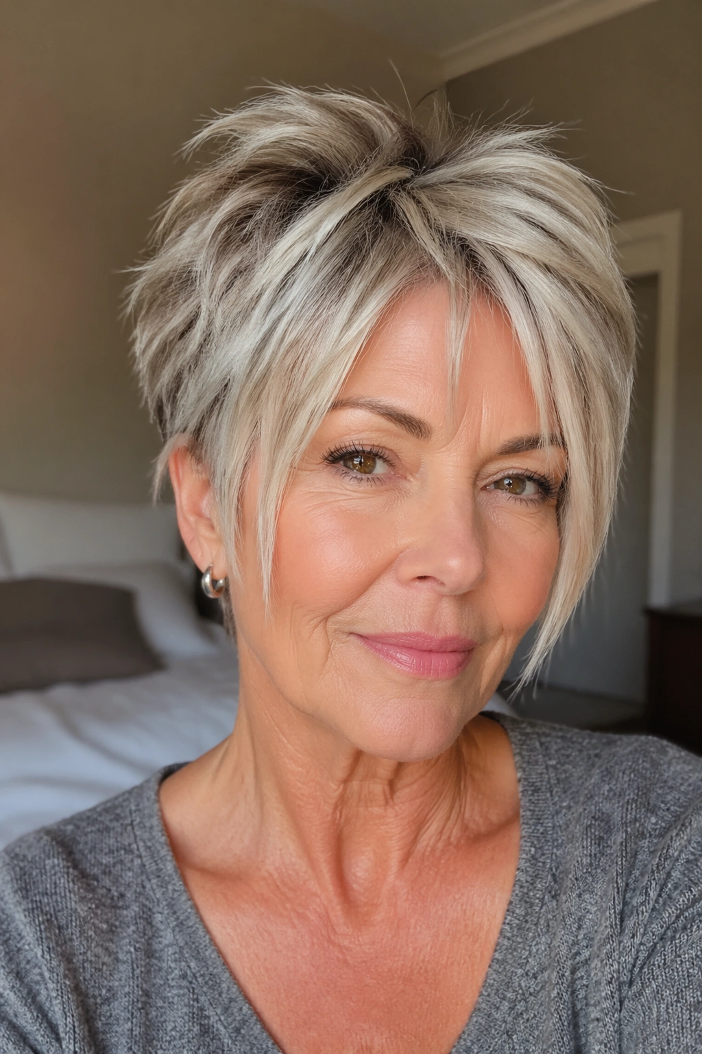 Close-up portrait of an older woman with a choppy crop and face-framing strips highlighting eyes and cheekbones