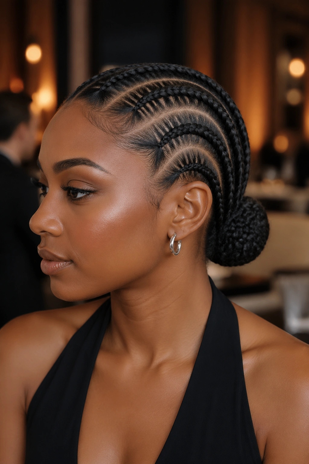 Close-up of a real woman with cornrows feeding into a wrapped bun