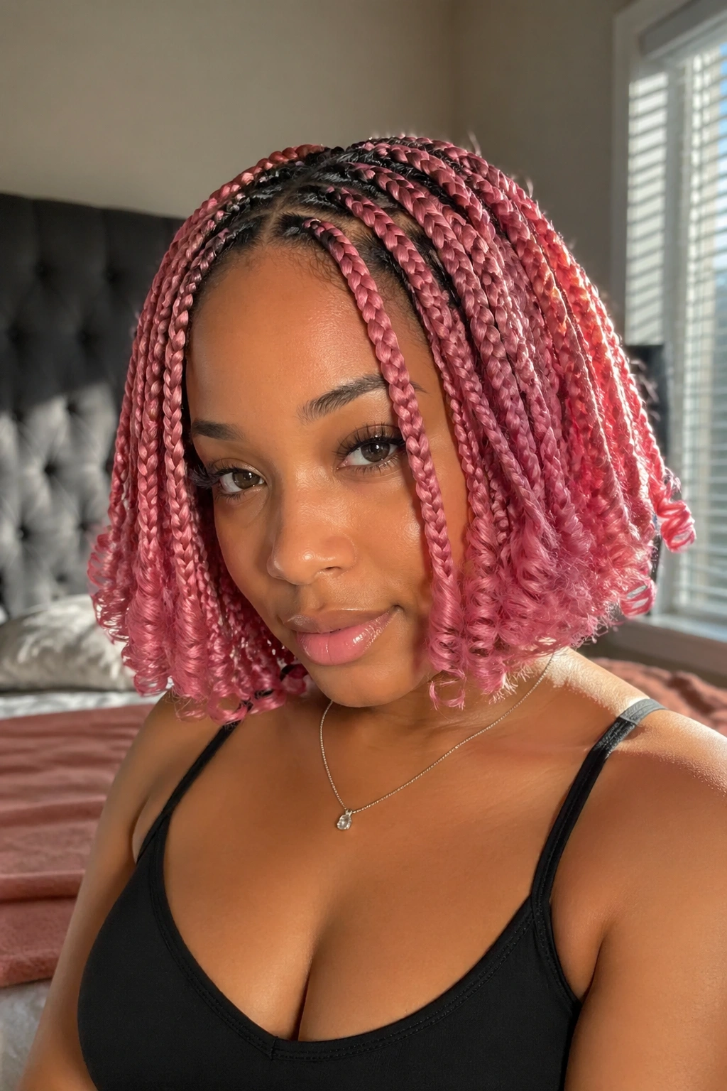 Close-up of real woman with curled pink box braids showing soft volume at the ends