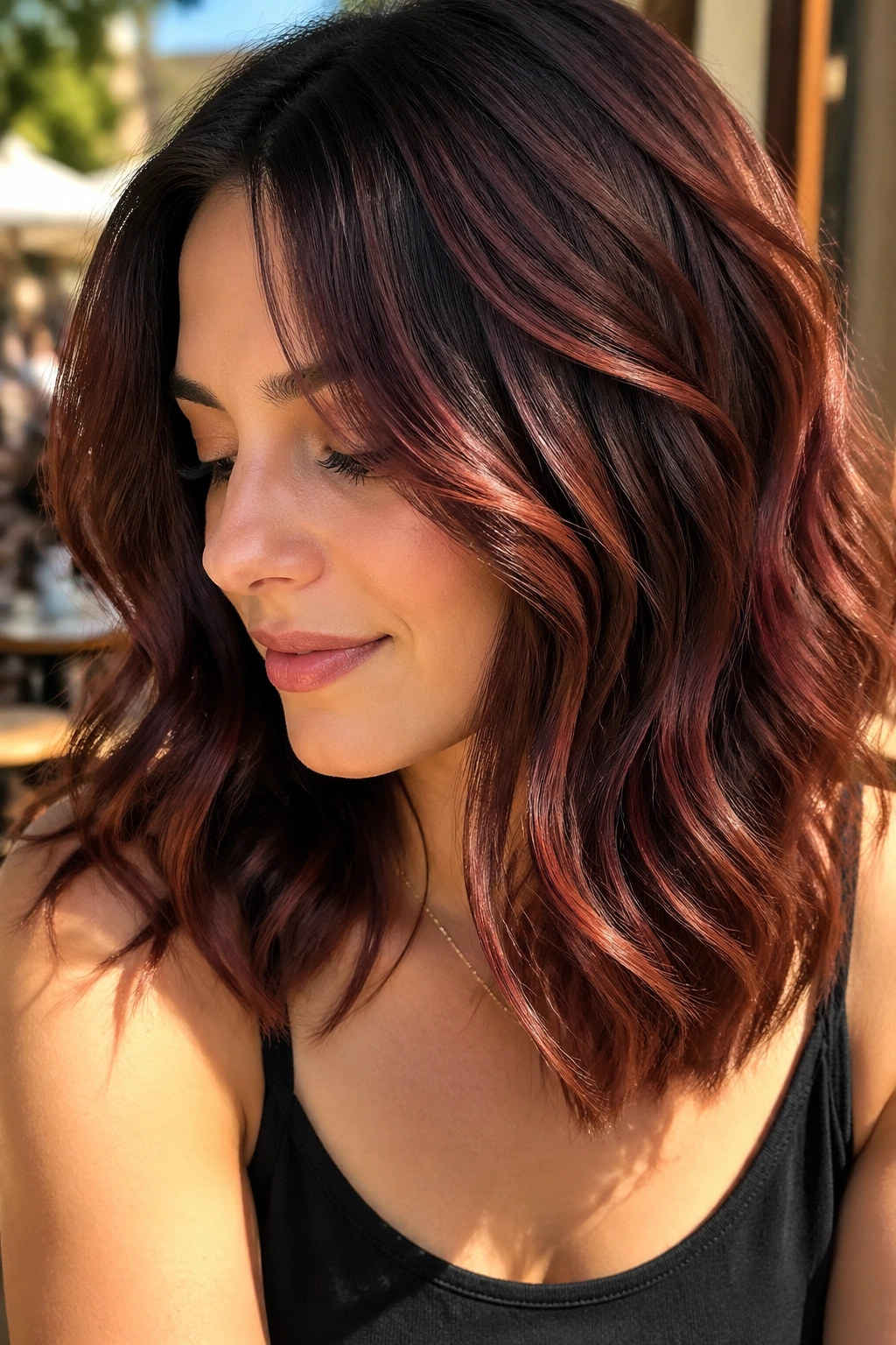 Portrait of a person with wavy hair featuring mahogany ribbons in sunlight.