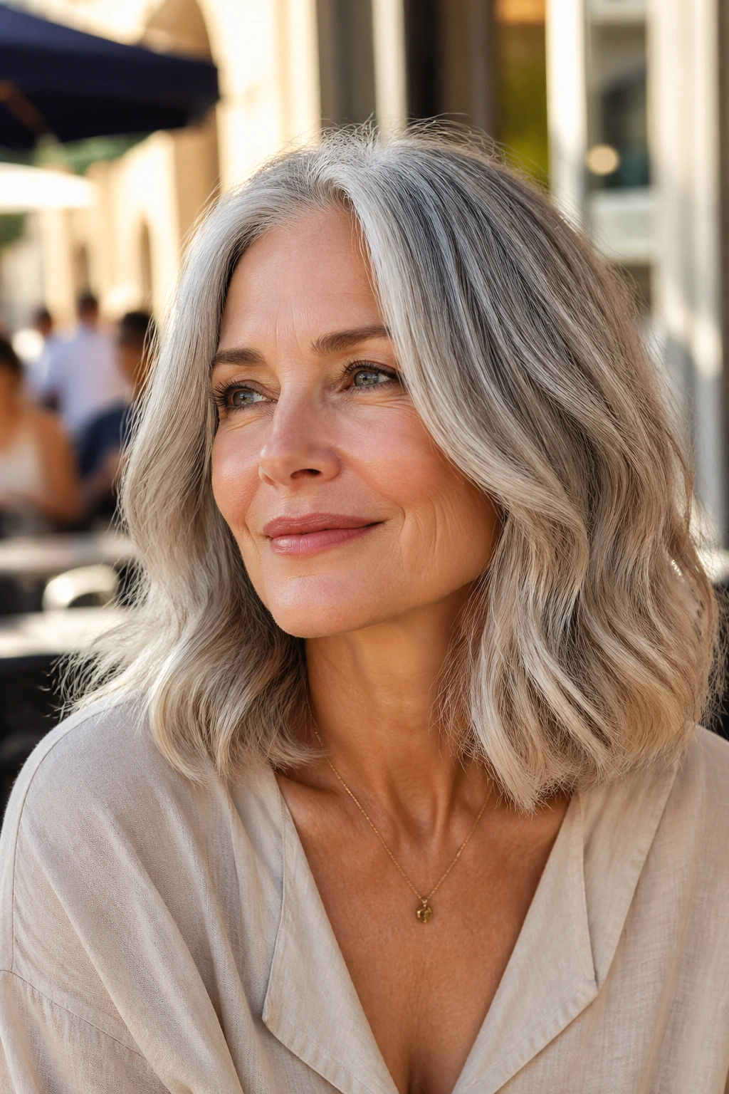Real woman with wavy collarbone-length gray hair and glossy finish in natural light.
