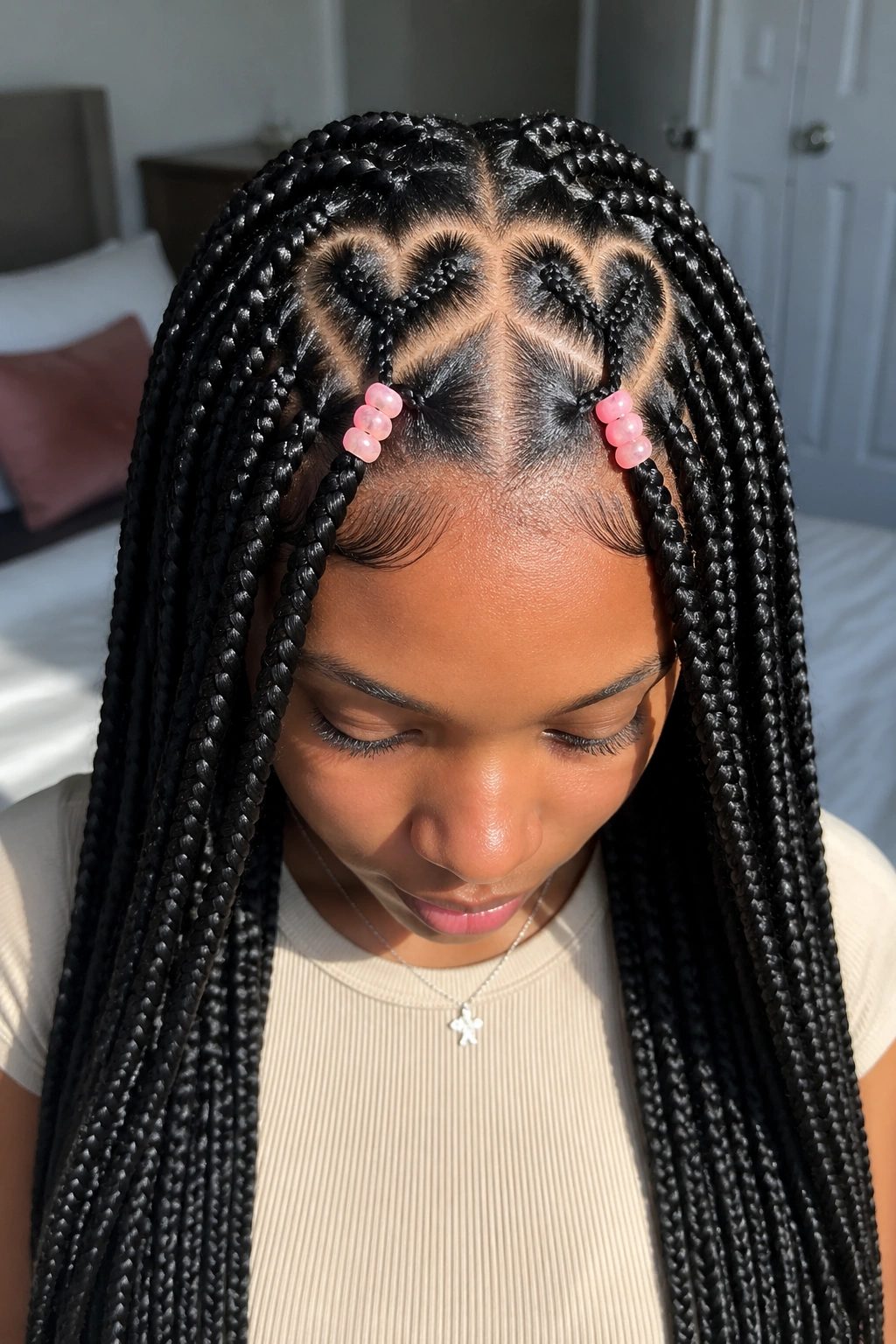 Close-up of heart-shaped parts in knotless box braids with soft pink beads