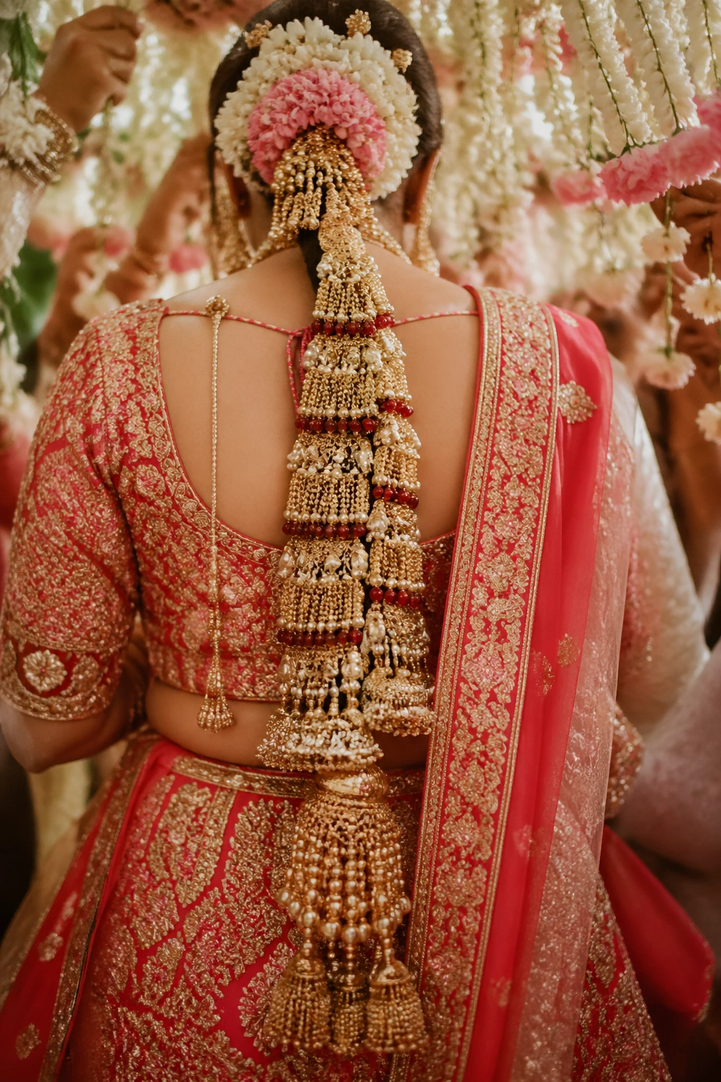 Bride under flowers wearing a heavy parandi