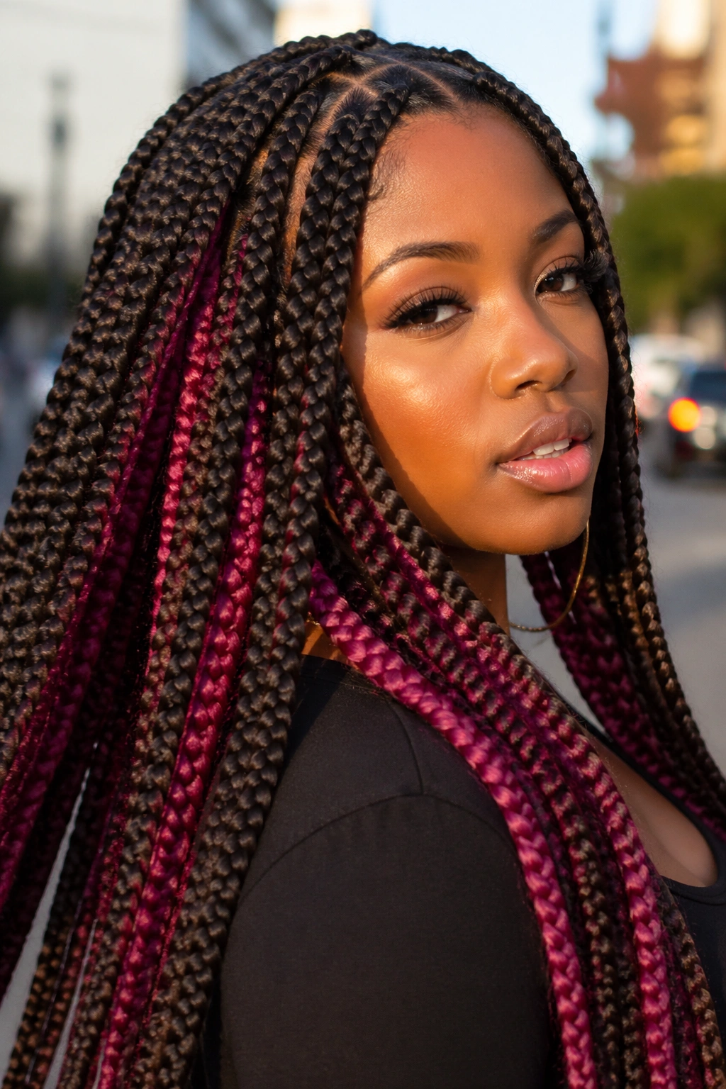 Close-up of espresso brown jumbo braids with magenta panels on a real person.