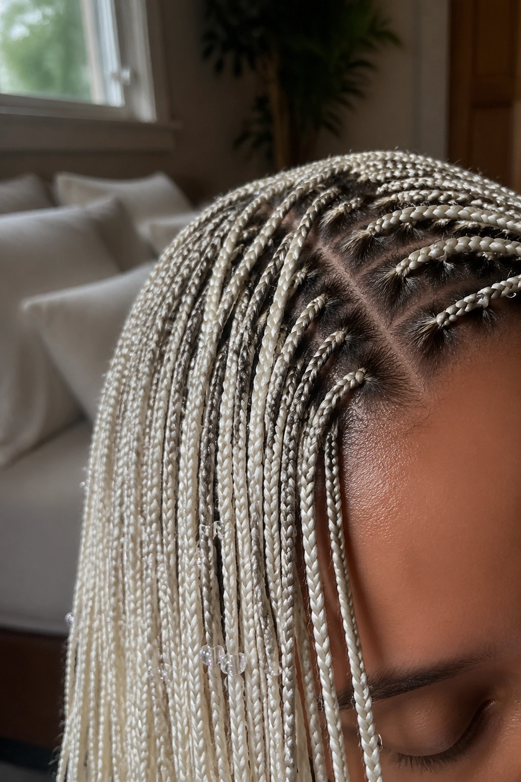 Close-up of micro white box braids with tiny seed beads on a real person