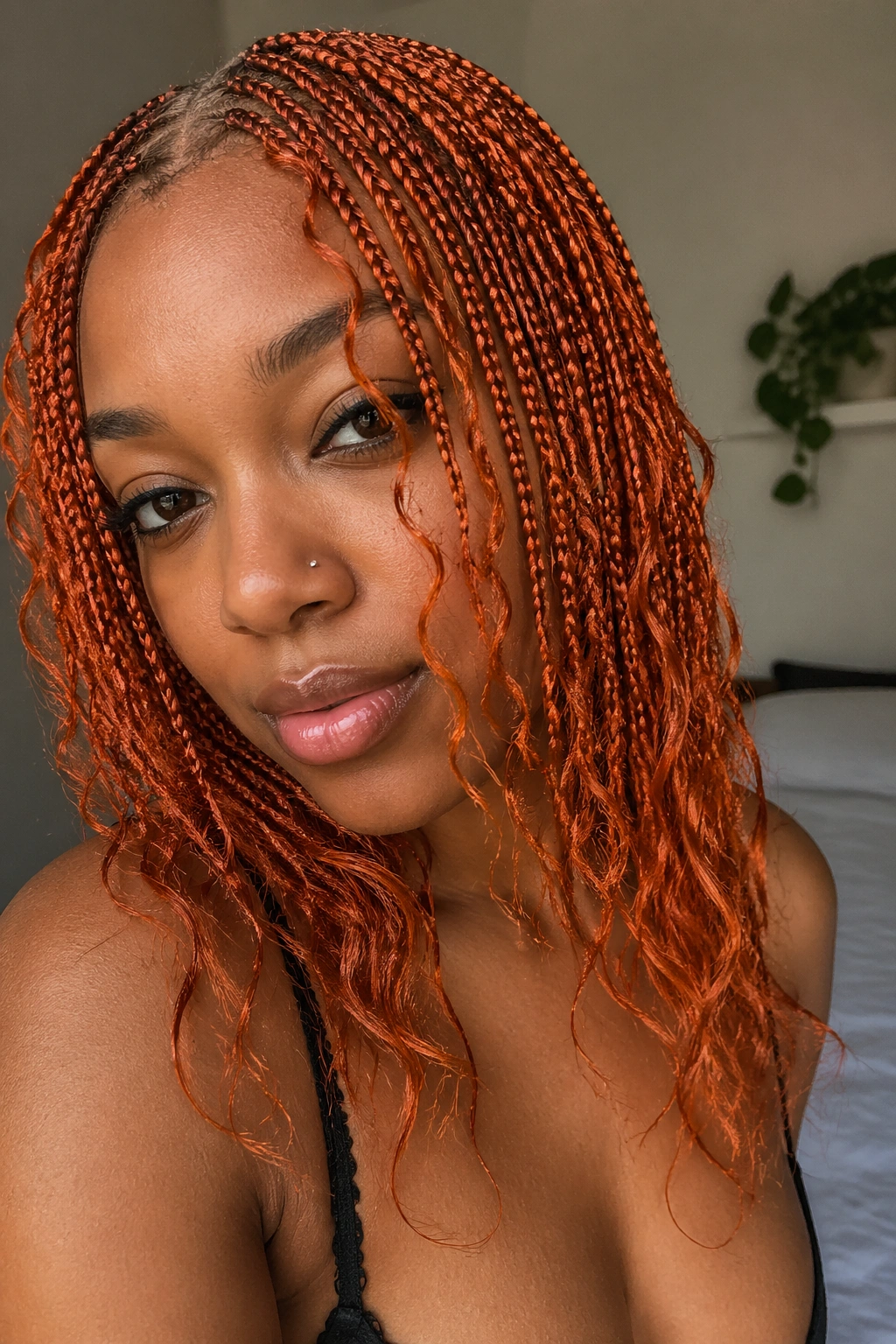 Close-up of real woman with micro orange box braids and wispy tips.