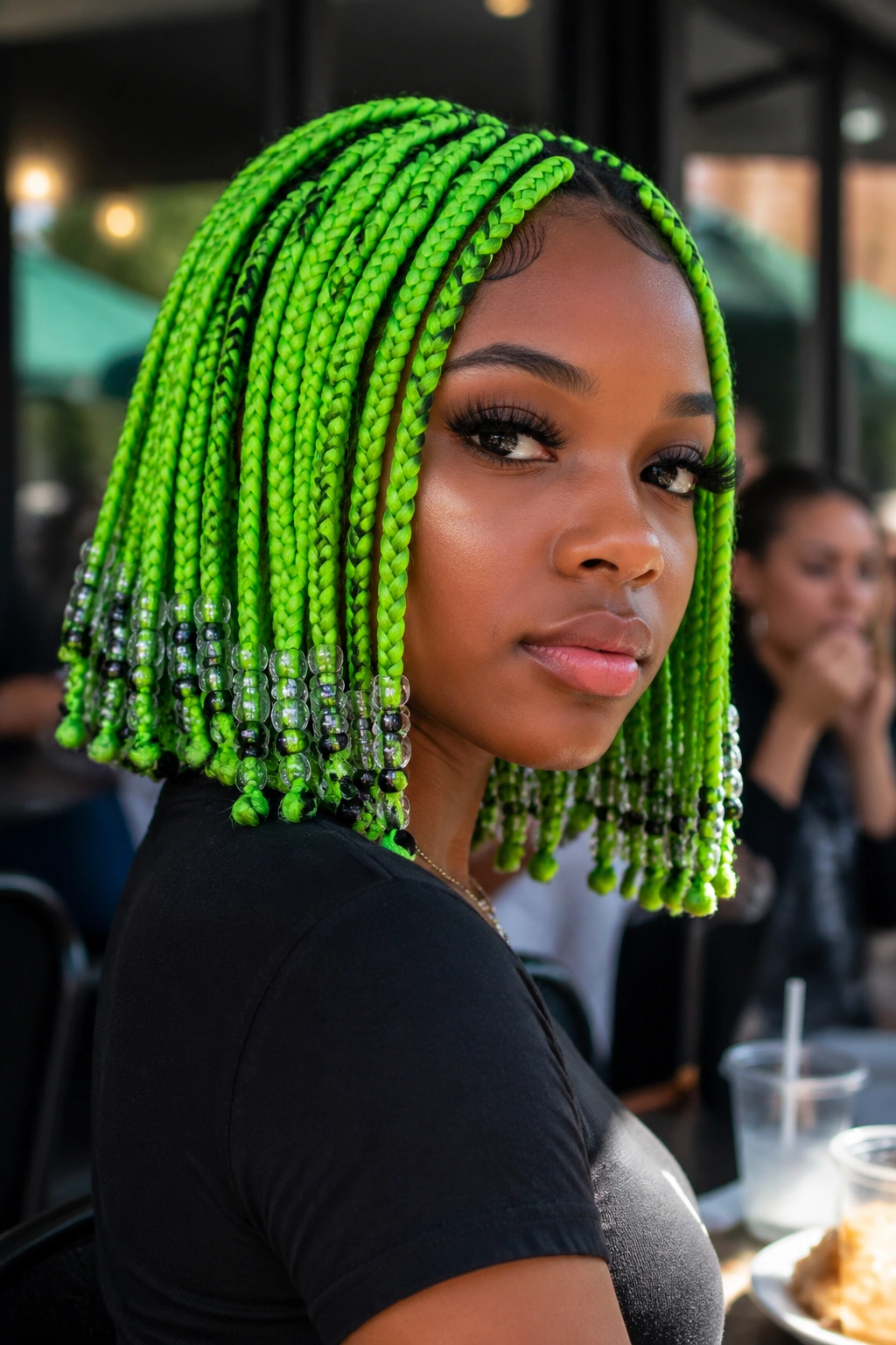 Close-up of neon green bob with faceted beads on a real person