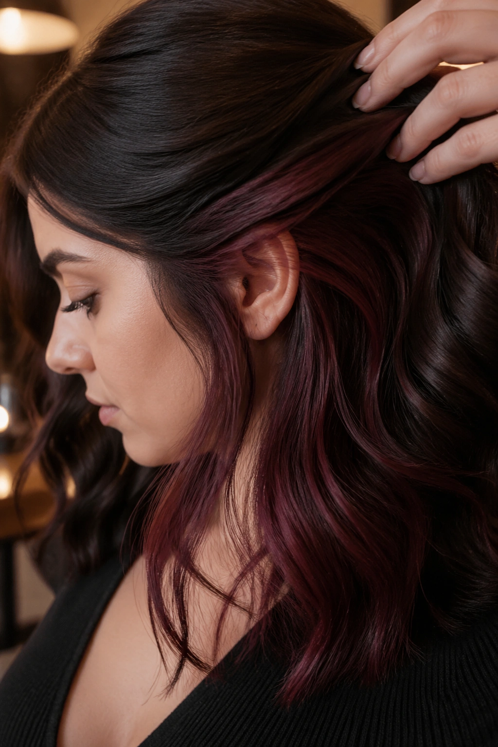 Portrait of a person with peekaboo mahogany panels under dark hair near the ear.