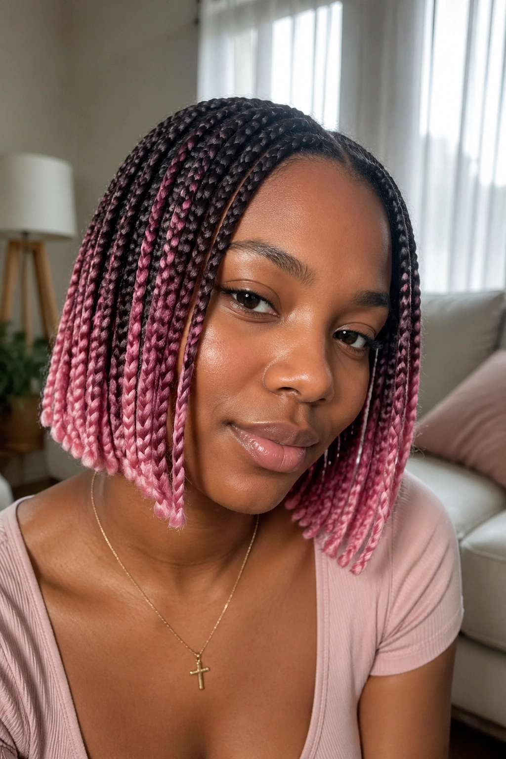 Close-up of real woman with dark roots fading to pink ombre on short box braids