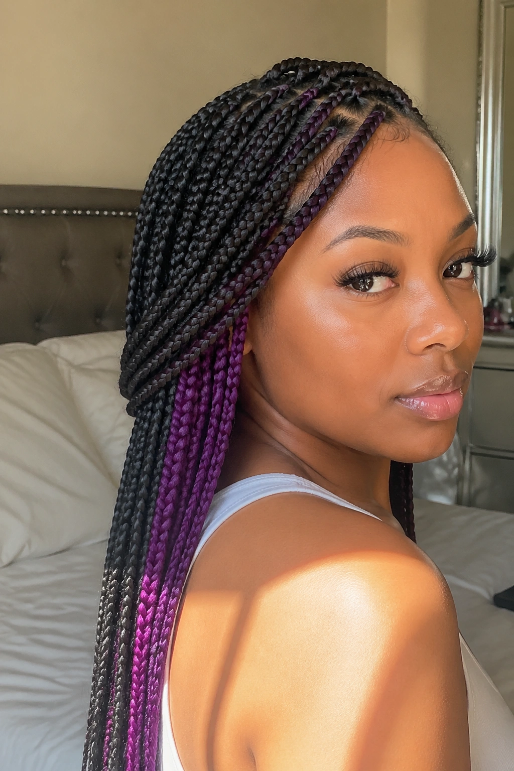 Close-up of a real woman's medium box braids showing hidden plum panels under the surface