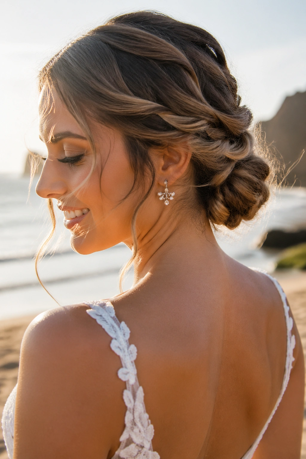 Close-up of a bride with a low rope braid bun at the nape on a beach setting