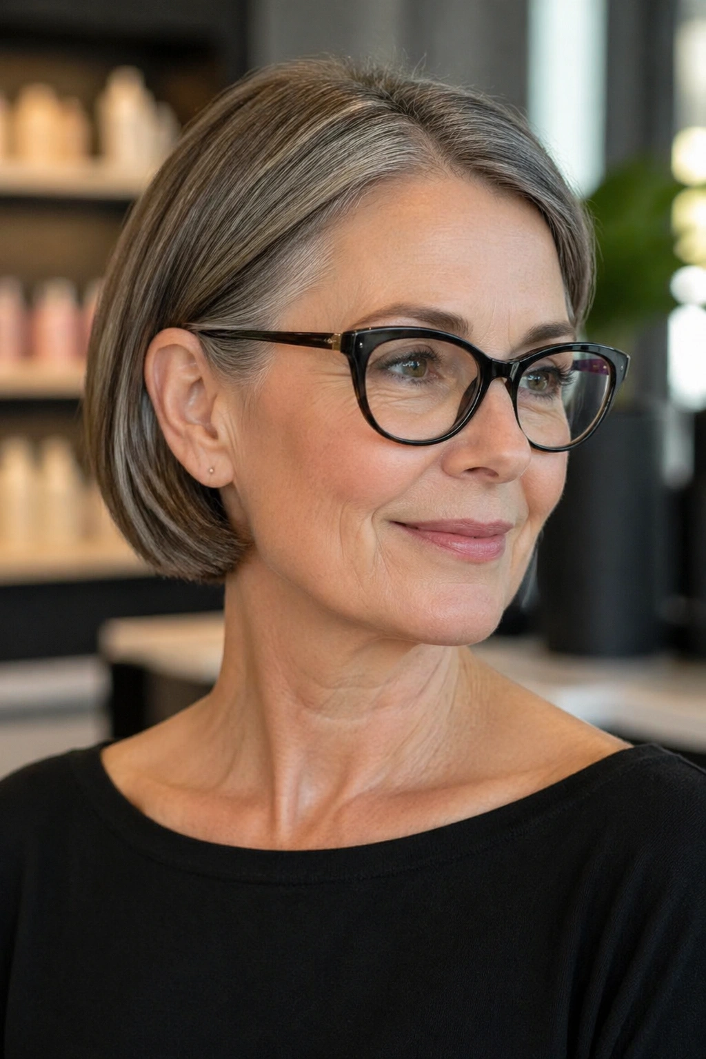 Real woman with sleek ear-tucked bob in a soft-lit salon setting