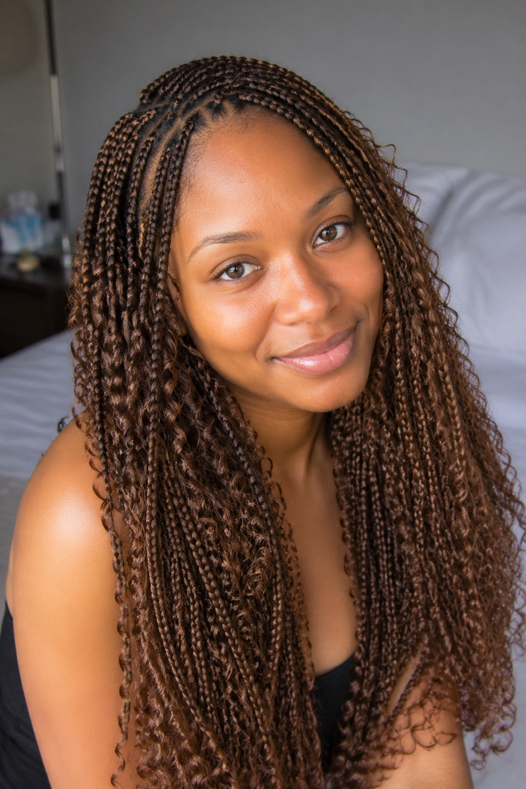 Close-up of a real woman with small brown knotless box braids and dense curl pieces