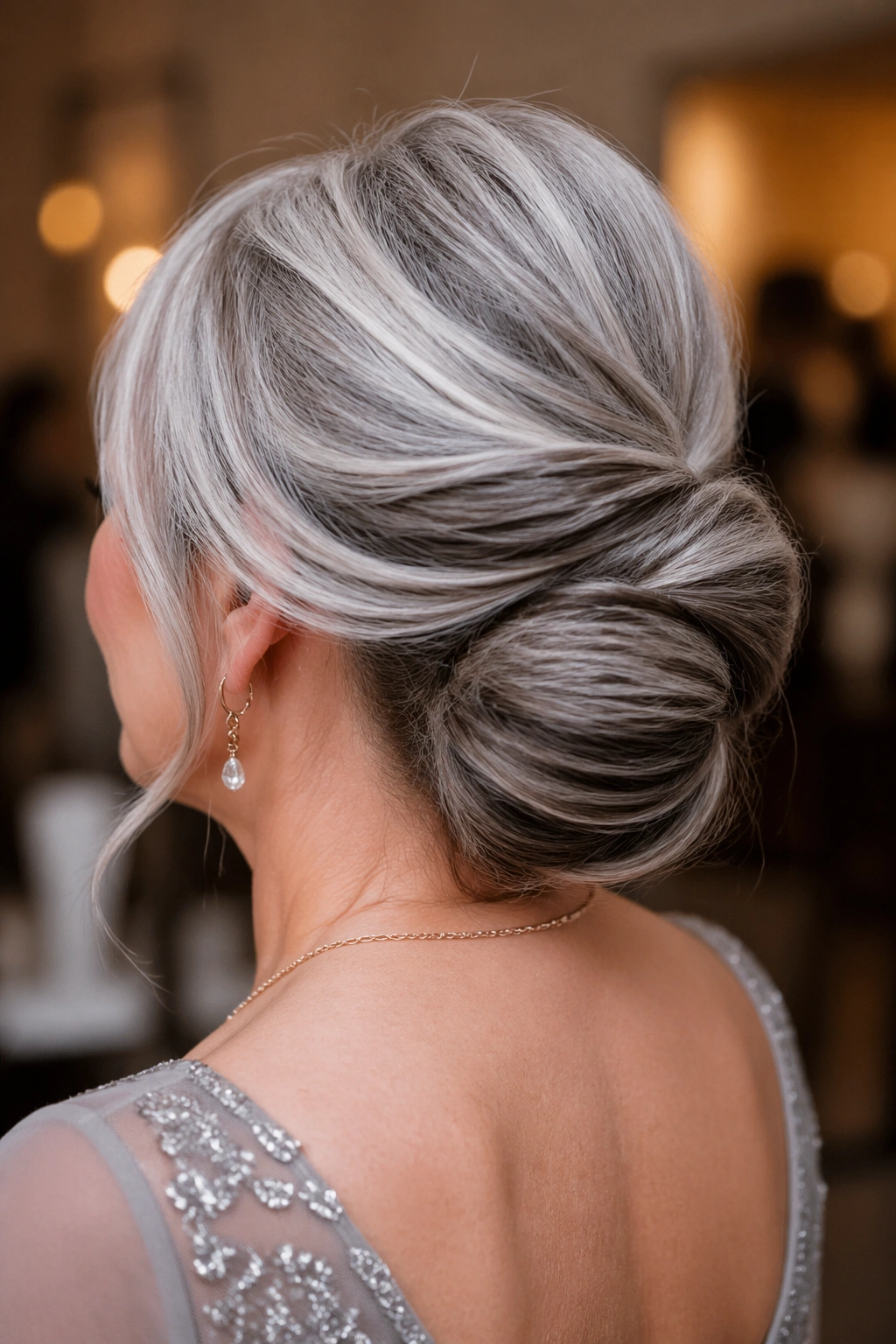 Real woman in a soft chignon showing hidden brown lowlights under the twists.