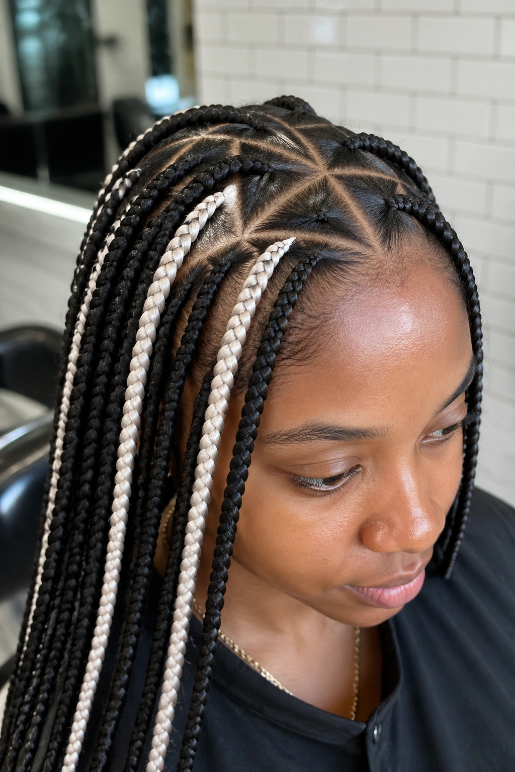 Real person with triangle-part braids and white strand in a bright salon setting