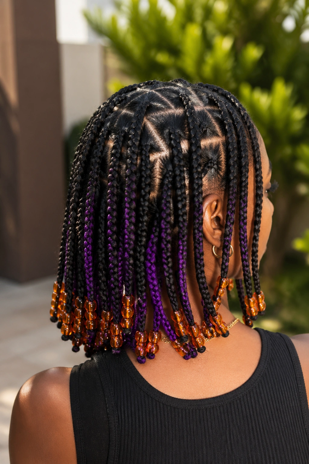 Three-quarter view of a real woman with violet peekaboo underbraids and amber beads