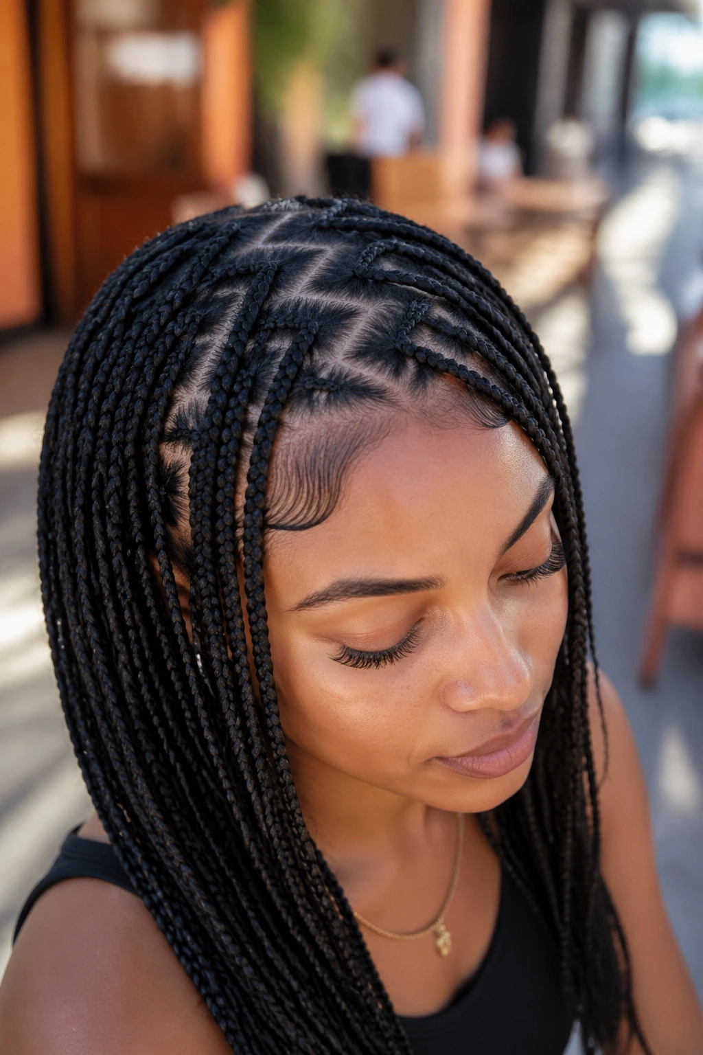 Close-up of a real woman with zig-zag parting on knotless braids across the crown