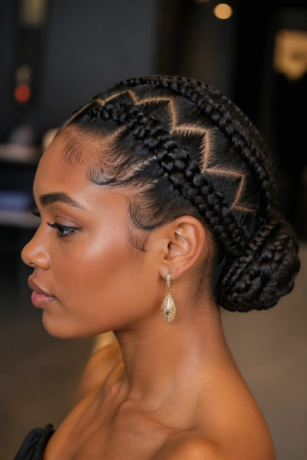 Close-up of a woman showing a zig-zag part braided updo from the side