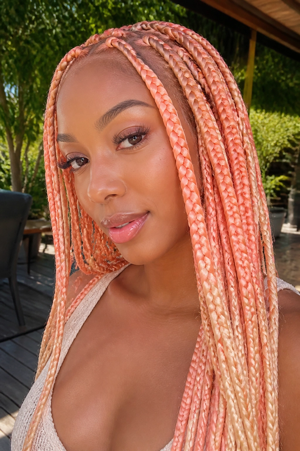 Close-up of real person with peach pastel knotless braids in sunlight