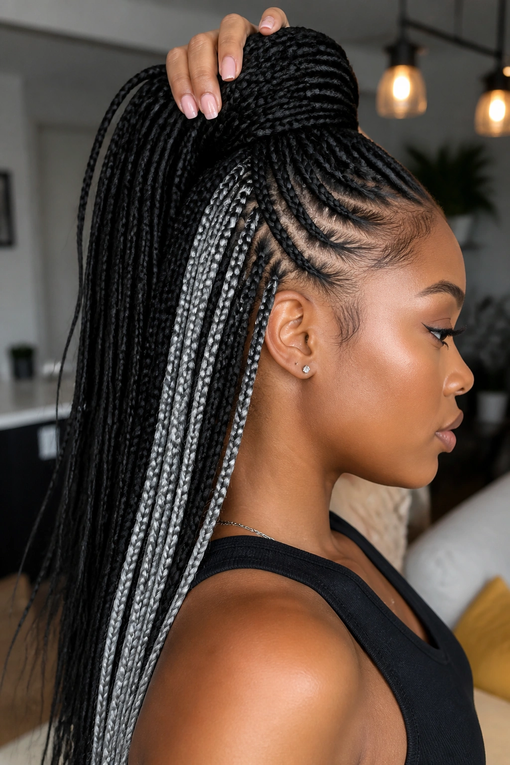 Side profile showing silver streaks under black braids with high ponytail