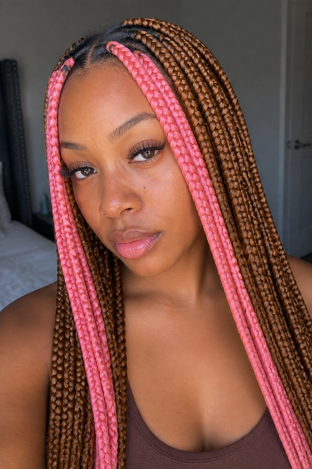 Close-up portrait of a real woman with golden brown hair and pink skunk stripe framing her face